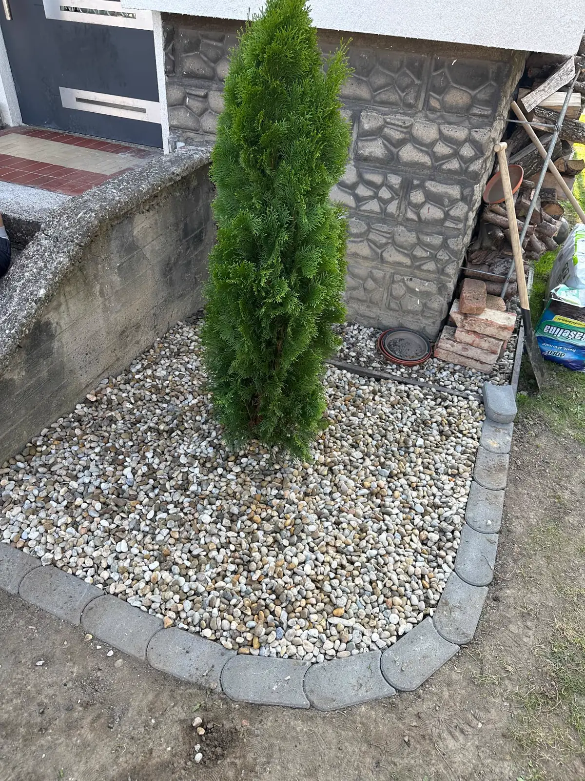 Okrasná kamínková plocha s tújí a betonovou obrubou